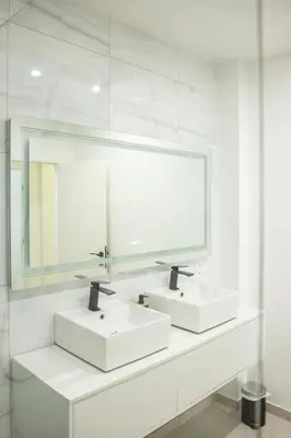 a white bathroom with two sinks and a mirror at Brussels South - Cosy Appartment in Brussels
