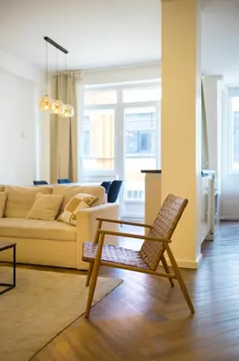 a living room with a chair and a couch at Brussels South - Cosy Appartment in Brussels