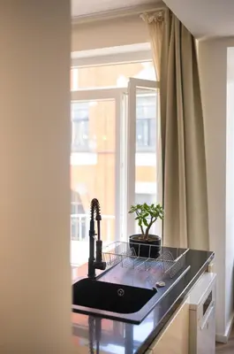 a bathroom with a black sink and a window at Brussels South - Cosy Appartment in Brussels