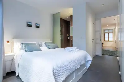 a bedroom with a large white bed with towels on it at Luxury Deluxe Garden Condo in Brussels Centre in Brussels
