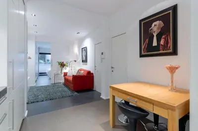 a living room with a desk and a red couch at Luxury Deluxe Garden Condo in Brussels Centre in Brussels