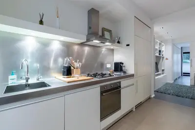 a white kitchen with a sink and a stove at Luxury Deluxe Garden Condo in Brussels Centre in Brussels