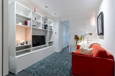 a living room with a red couch and a tv at Luxury Deluxe Garden Condo in Brussels Centre in Brussels