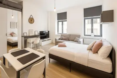 a bedroom with a bed and a living room at Toison d'Or Apartment in Brussels