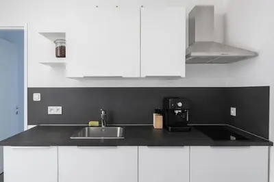 a kitchen with white cabinets and a sink at Toison d'Or Apartment in Brussels