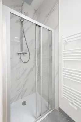 a shower with a glass door in a bathroom at Cozy Brabanconne apartment in Brussels