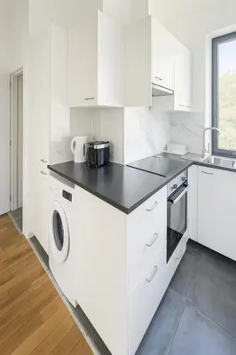 a white kitchen with a sink and a dishwasher at Cozy Brabanconne apartment in Brussels