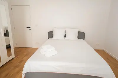 a white bed with two pillows on top of it at Cozy Brabanconne apartment in Brussels