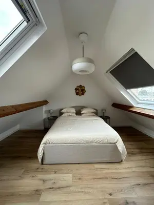 a white bedroom with a bed and two windows at 5- Nid lumineux 2 chambres au plein coeur d'Ixelles in Brussels