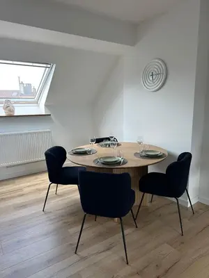 a dining room table with four chairs and a window at 5- Nid lumineux 2 chambres au plein coeur d'Ixelles in Brussels