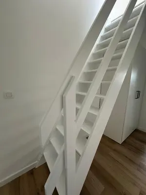 a white staircase with white shelves in a room at 5- Nid lumineux 2 chambres au plein coeur d'Ixelles in Brussels
