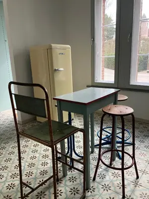 a table and a chair next to a refrigerator at Tampico, Holiday Home at river Schelde in Hamme