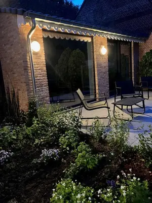 a patio with a bench and lights in a garden at Tampico, Holiday Home at river Schelde in Hamme