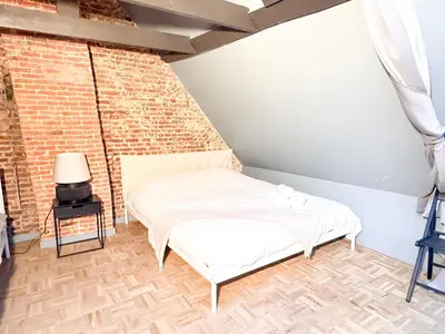 a bed in a room with a brick wall at NEW Central old town - Exclusive Residences in Antwerp