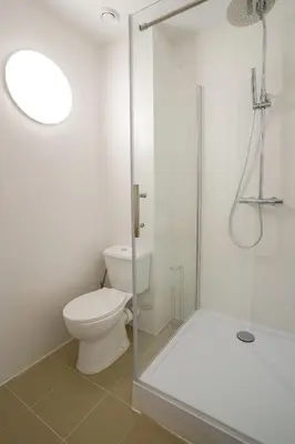 a white bathroom with a toilet and a shower at Malbeek 7 in Brussels