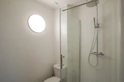 a white bathroom with a shower and a toilet at Malbeek 7 in Brussels