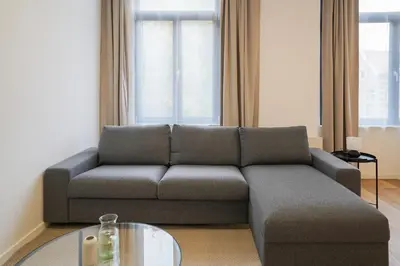 a living room with a couch and a glass table at Appartment Jacobs 6 in Brussels