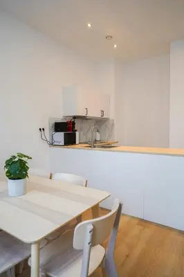 a white kitchen with a table and chairs at Appartment Jacobs 6 in Brussels