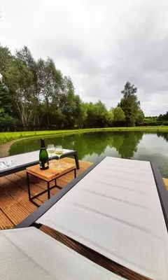 a boat deck with a table and a wine bottle on it at Black Pearl in Hamme