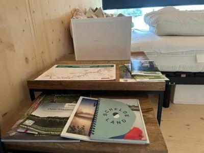 a table with books on it next to a bed at Black Pearl in Hamme