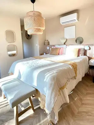 a bedroom with a large bed with a bench at Chambre d Amis in Lokeren