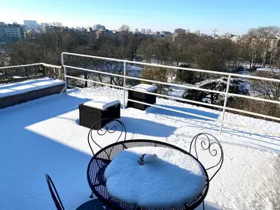 a table and chairs covered in snow on a balcony at Fuths Penthouse 55 in Antwerp