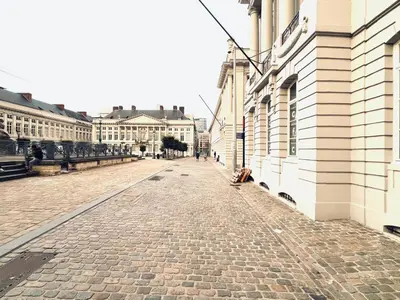 a cobblestone street in a city with buildings at Oase in the City in Brussels