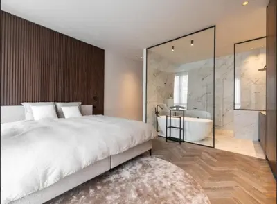 a bedroom with a large bed and a bath tub at Luxury Designer Penthouse with Roof Terrace in Antwerp