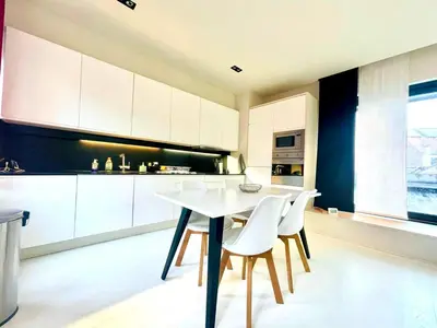 a kitchen with a white table and white chairs at Elegant Central Apartment Quiet and Bright in Brussels
