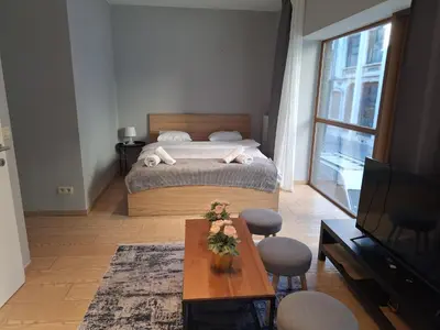 a bedroom with a bed and a table and a tv at Résidence des sables in Brussels