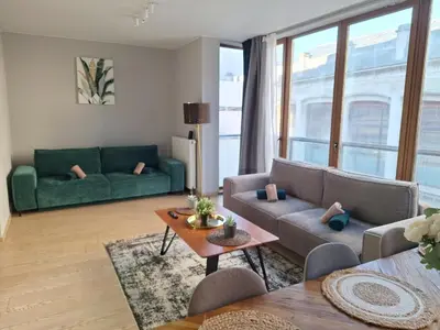 a living room with a couch and a table at Résidence des sables in Brussels