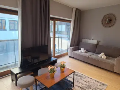 a living room with a couch and a table and a tv at Résidence des sables in Brussels