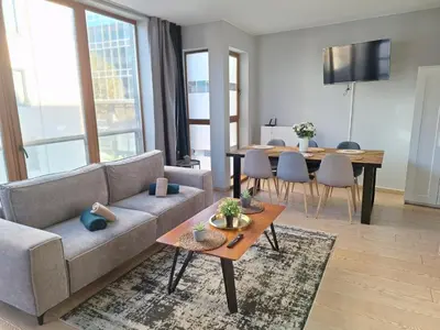 a living room with a couch and a table at Résidence des sables in Brussels