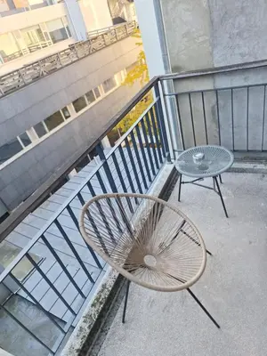 a chair and a table on a balcony at Résidence des sables in Brussels