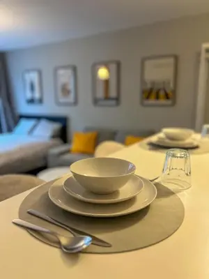 a table with plates and a bowl and a glass at Loft Tarantino au cœur de Bruxelles in Brussels
