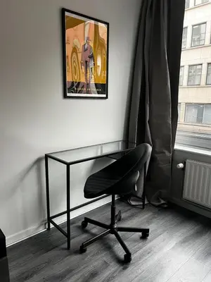a desk and a chair in a room with a painting at Loft Tarantino au cœur de Bruxelles in Brussels