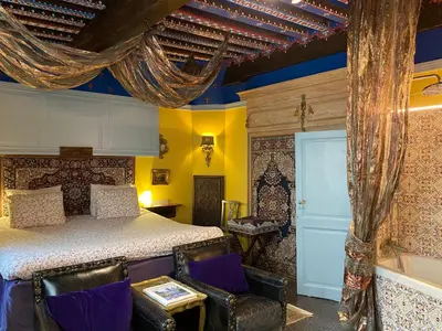a bedroom with a bed and chairs in it at House Le Prince D'Anvers in Antwerp