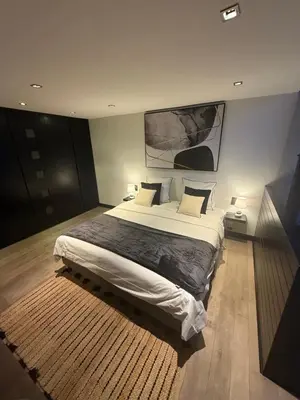 a bedroom with a large bed and a painting on the wall at Maison d'hôte Yourehome 2 belles chambres à louer individuellement dans un écrin de verdure in La Hulpe