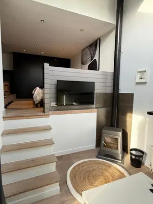 a living room with a staircase and a fireplace at Maison d'hôte Yourehome 2 belles chambres à louer individuellement dans un écrin de verdure in La Hulpe