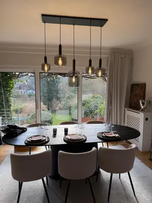 a dining room with a table and chairs with lights at Maison d'hôte Yourehome 2 belles chambres à louer individuellement dans un écrin de verdure in La Hulpe