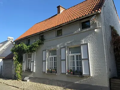 a white brick house with windows and plants at Maison d'hôte Yourehome 2 belles chambres à louer individuellement dans un écrin de verdure in La Hulpe