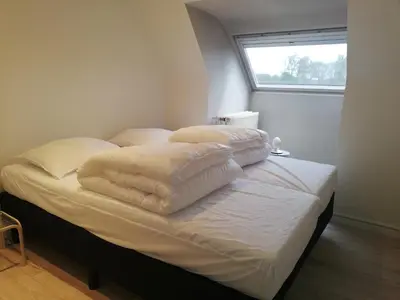 a bed with white sheets and pillows on it at Splendid villa in Flemish Ardennes with pool in Wolvenhoek