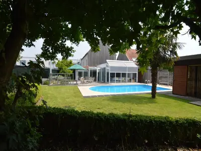 a swimming pool in a yard next to a building at Splendid villa in Flemish Ardennes with pool in Wolvenhoek