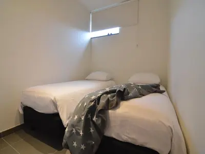 two beds in a small bedroom with a light above them at Holiday home in Zottegem in Zottegem