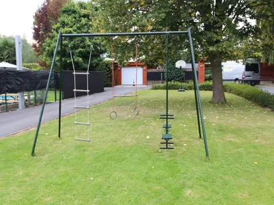 an empty swing set on the grass in a park at Holiday home in Zottegem in Zottegem