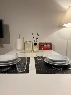 a table with two glasses and plates and a lamp at Briefstreet - Louvain in Leuven