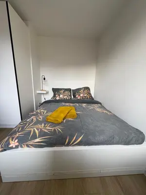 a bedroom with a bed with a yellow blanket on it at Briefstreet - Louvain in Leuven