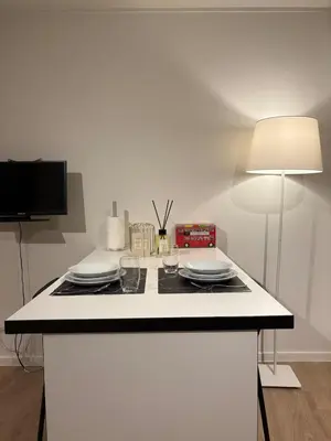 a white kitchen with a counter with plates and a lamp at Briefstreet - Louvain in Leuven