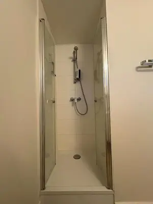 a shower with a glass door in a bathroom at Briefstreet - Louvain in Leuven