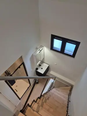 a staircase with a mirror and a sink in a room at Huis ALNA 10 in Mechelen